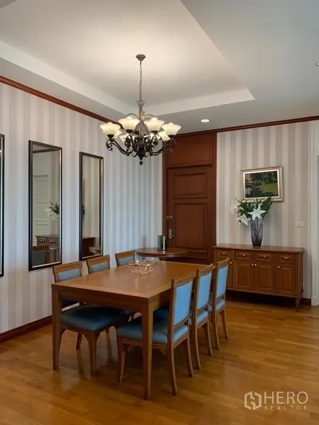 公寓 出租在Khlong Toei, Bangkok - 餐厅配六人木餐桌、吊灯、装饰镜与边柜。