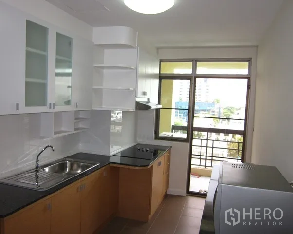 คอนโด ให้เช่าหรือขายในWatthana, Bangkok - ครัวสว่าง ตู้สีขาว ท็อปหินสีดำ และประตูออกระเบียง