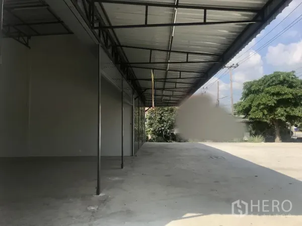 Warehouse for rent in Lam Luk Ka, Pathum Thani - Side canopy and loading bay running along the warehouse with spacious driveway.