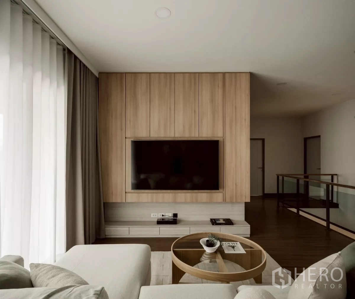 Detached House for rent in Bang Phli, Samut Prakan - TV feature wall opposite sofa beside glass stair railing