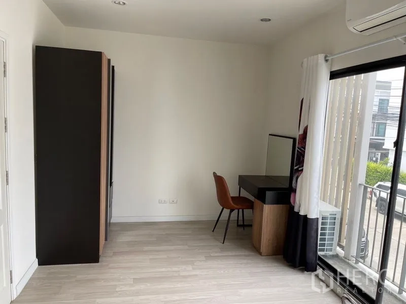 Townhouse for rent in Bang Kapi, Bangkok - Bright room with wardrobe, dressing desk, sliding glass door and light wood flooring.