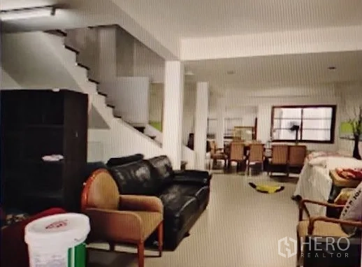 Home Office for rent in Khlong Toei, Bangkok - Open-plan ground floor living and work area with sofa seating, dining set, columns and staircase.