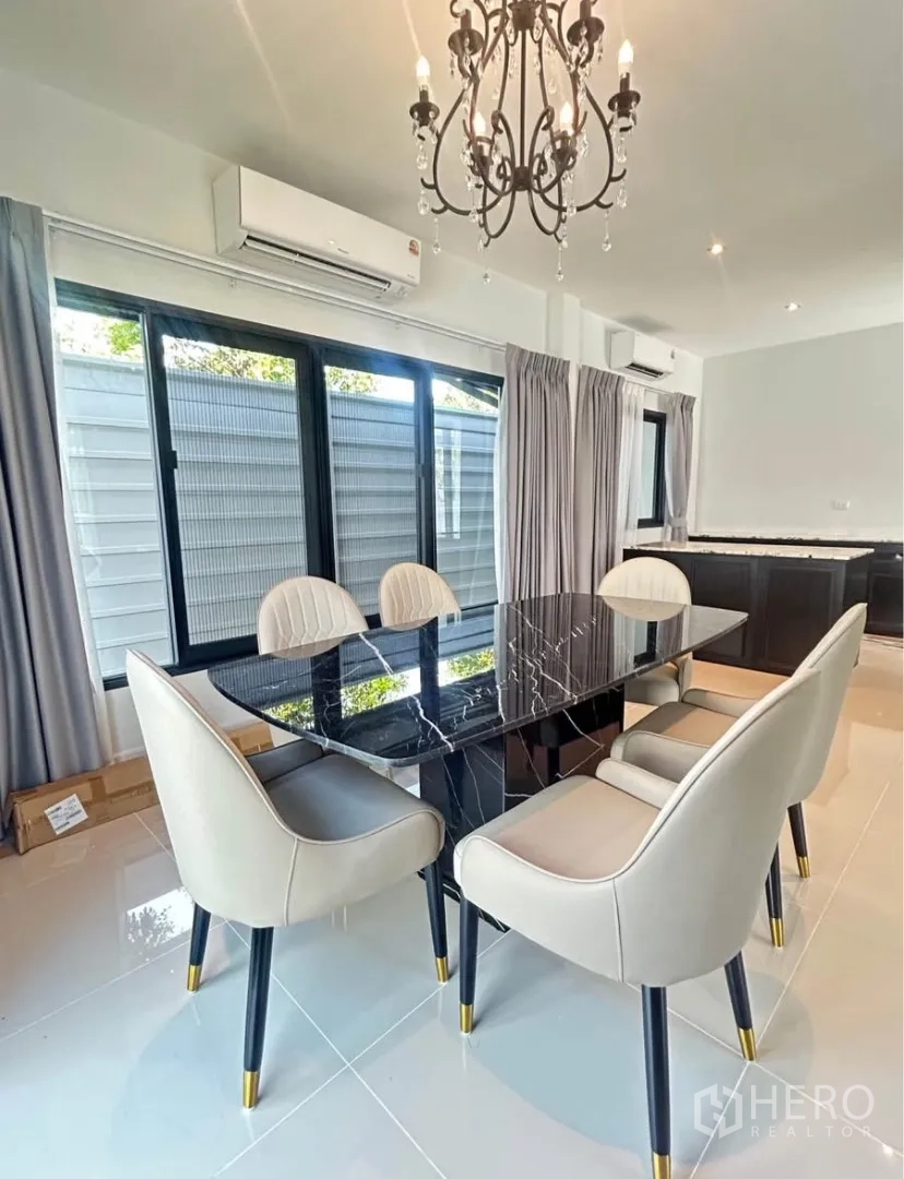 บ้านแฝด for rent in Bang Phli, Samut Prakan - ห้องรับประทานอาหารโต๊ะหินอ่อนสีดำ เก้าอี้บุนวม และโคมระย้า ข้างหน้าต่างบานใหญ่