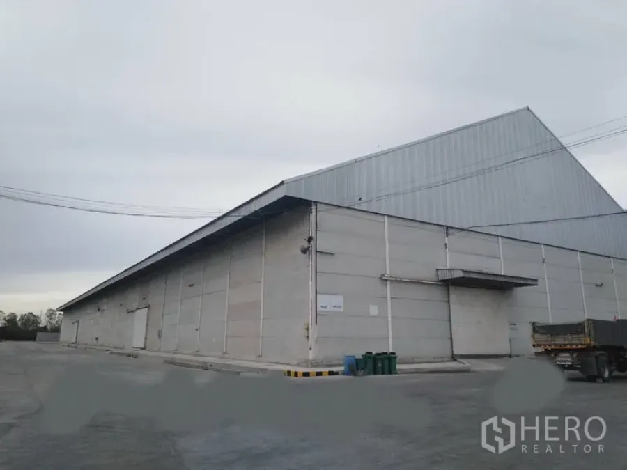 货栈 出租在Phra Nakhon Si Ayutthaya - 仓库外观，装卸雨棚与宽阔车道，卡车出入便捷。