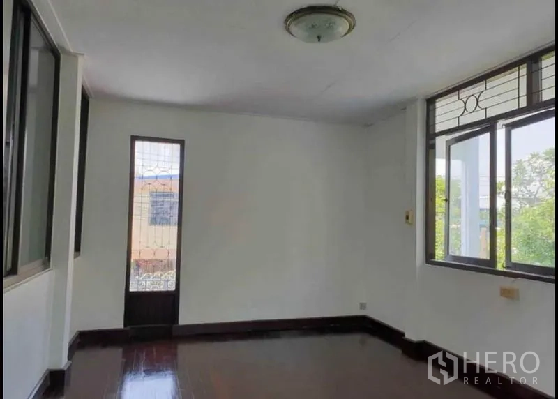 บ้าน ให้เช่าในLat Phrao, Bangkok - ห้องนอนชั้นบน พื้นไม้ หน้าต่าง และประตูกระจกแคบออกสู่ระเบียง