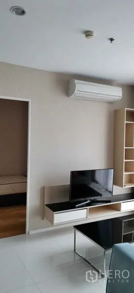 公寓 出租在Watthana, Bangkok - 客厅带壁挂电视柜、开放式书架与空调。