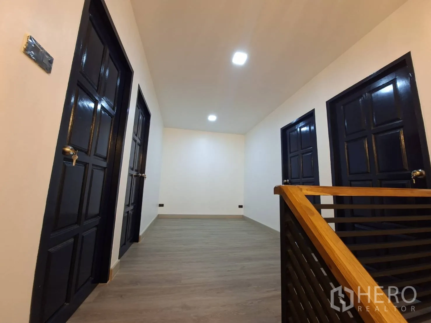 家庭办公室 for rent in Phra Khanong, Bangkok - 楼上走廊，多扇深色房门与木纹地面。