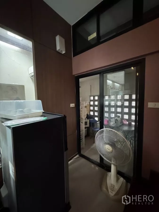 店屋 出租在Bang Rak, Bangkok - 紧凑的杂物间，配冰箱、推拉玻璃门与立式风扇。