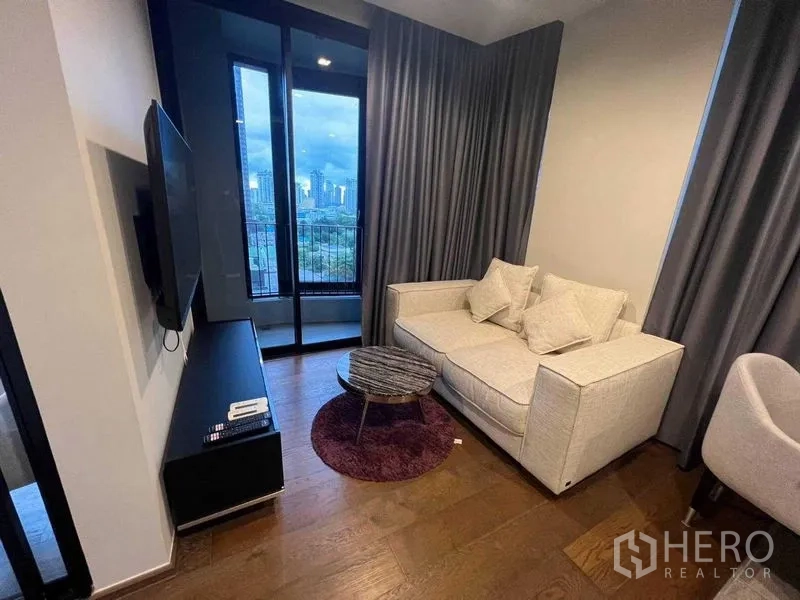 คอนโด ให้เช่าในKhlong Toei, Bangkok - มุมห้องนั่งเล่นยามเย็น โซฟา โต๊ะกลม และประตูบานเลื่อนออกสู่ระเบียง