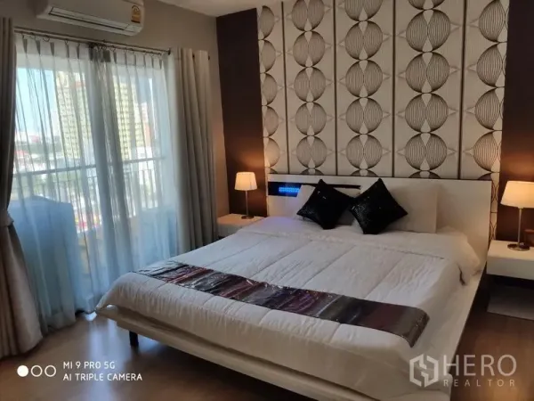 คอนโด ให้เช่าหรือขายในPathum Wan, Bangkok - ห้องนอนอบอุ่น เตียงคิง ผนังลายกราฟิก โคมไฟหัวเตียง และหน้าต่างสูงจรดเพดาน