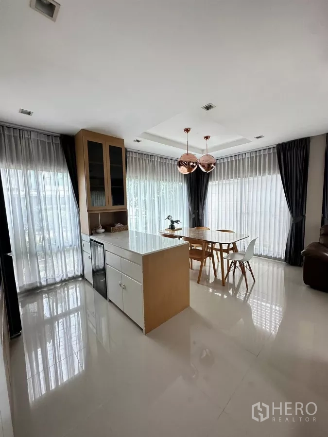 Detached House for rent in Saphan Sung, Bangkok - Open-plan dining area with island counter, pendant lights and floor-to-ceiling windows.