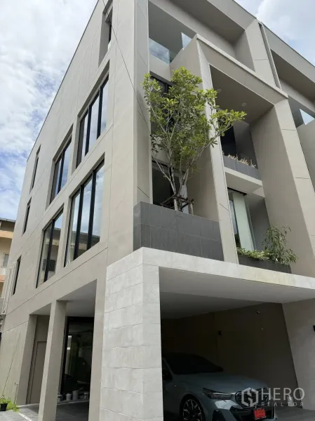 带办公室的家 出租或出售在Lat Phrao, Bangkok - 外立面另一角度，现代四层建筑，车库与阳台清晰可见。
