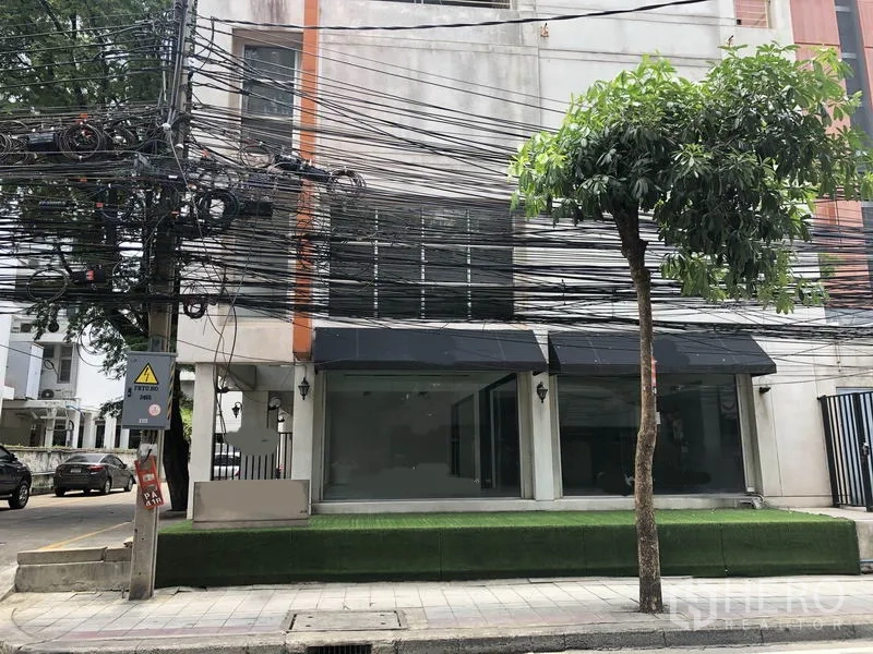 零售空间 出租在Watthana, Bangkok - 临街建筑立面，宽幅玻璃橱窗与深色雨篷。