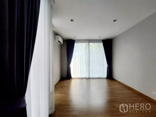 ทาวน์เฮาส์ ให้เช่าในLat Phrao, Bangkok - ห้องนอนกว้าง พื้นไม้ เครื่องปรับอากาศ และหน้าต่างบานใหญ่รับแสงธรรมชาติ