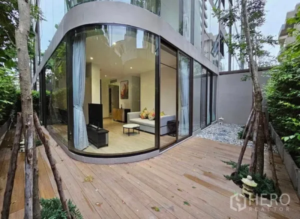 คอนโด ให้เช่าหรือขาย - คอนโดชั้นล่างมุมกระจกโค้งกับระเบียงไม้และสวนส่วนตัว