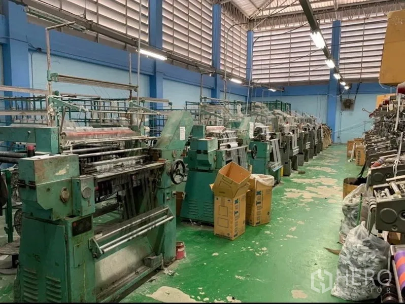 คลังสินค้า ขายในMueang Samut Sakhon, Samut Sakhon - แถวเครื่องจักรทอจำนวนมากในฮอลล์โกดังที่มีระบบระบายอากาศ