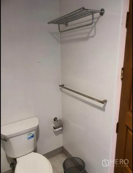 Condominium for rent in Ratchathewi, Bangkok - Clean bathroom with toilet, towel rail and wall-mounted rack.