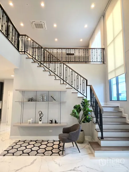 Detached House for rent in Bang Phli, Samut Prakan - Double-height foyer with feature staircase, iron balustrade and marble-look floors.