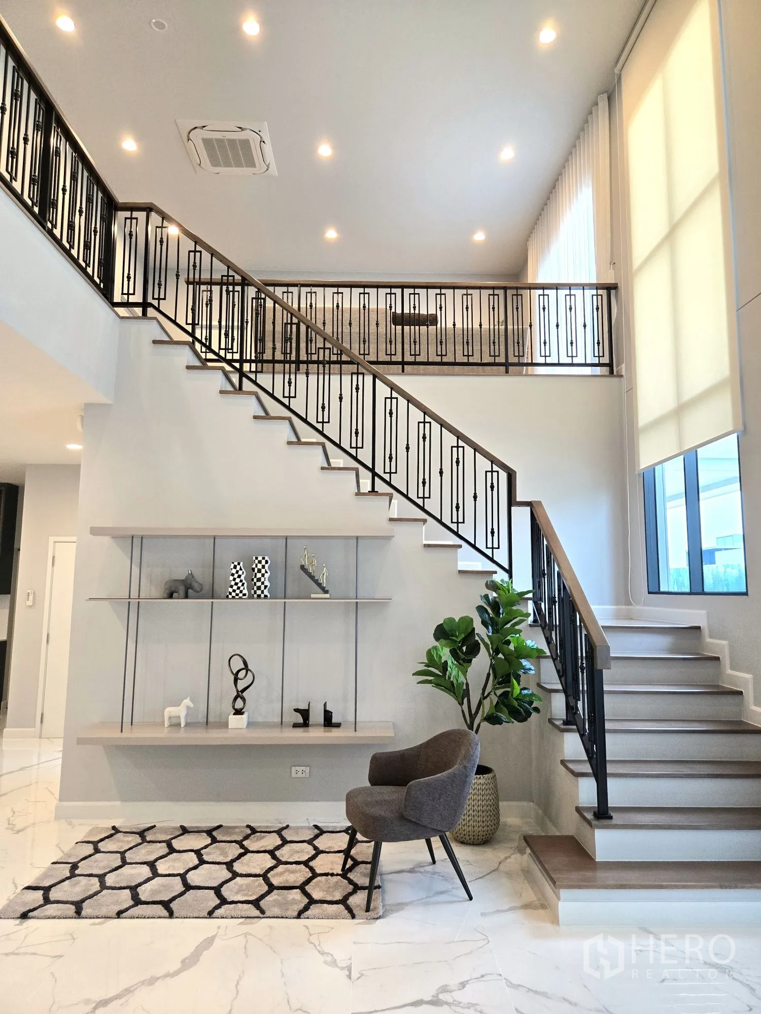 Detached House for rent in Bang Phli, Samut Prakan - Double-height foyer with feature staircase, iron balustrade and marble-look floors.
