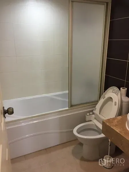 คอนโด ให้เช่าในWatthana, Bangkok - ห้องน้ำพร้อมอ่างอาบน้ำกั้นกระจก โถสุขภัณฑ์ และเคาน์เตอร์หิน