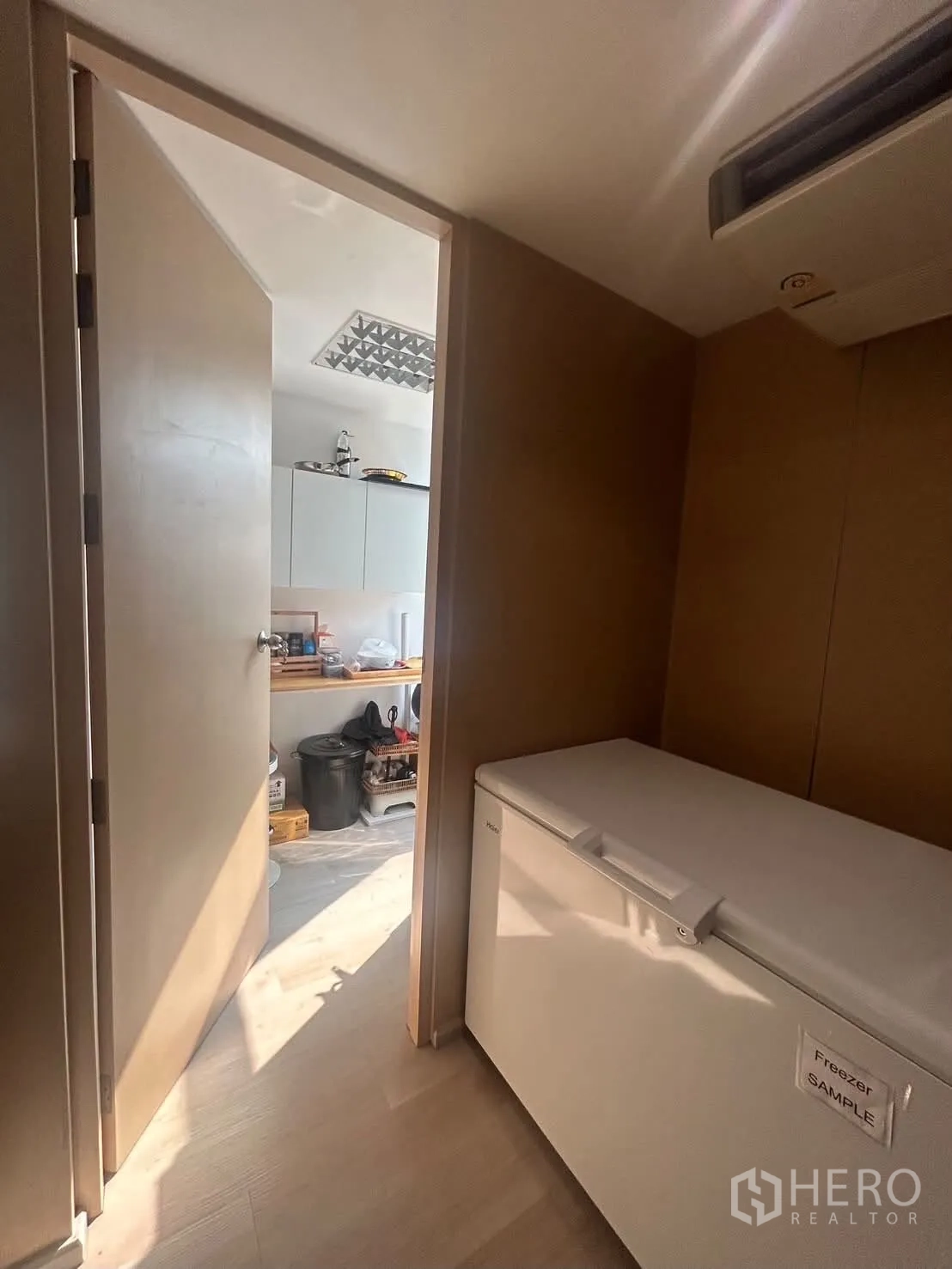 办公室 for rent in Bang Rak, Bangkok - 走廊内放置顶开式冰柜，通向带水槽与吊柜的杂物间