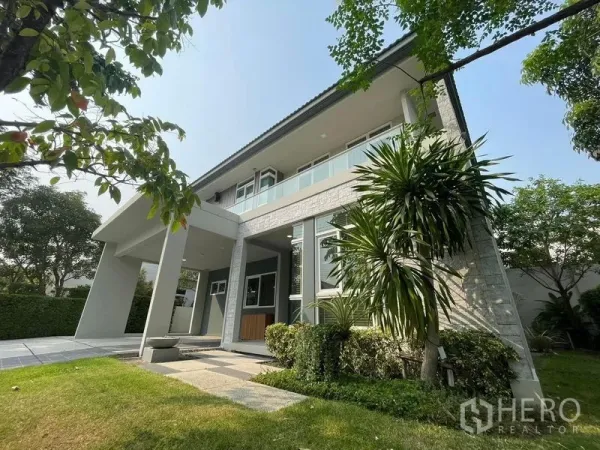 บ้าน ให้เช่าในPrawet, Bangkok - มุมหน้าบ้านเดี่ยวสองชั้นสไตล์โมเดิร์น มีระเบียง เฉลียง และสวนจัดแต่งในโครงการปิด