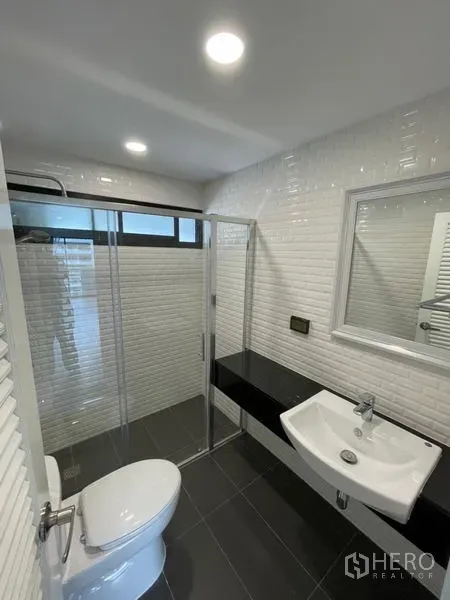 คอนโด ให้เช่าหรือขายในWatthana, Bangkok - ห้องน้ำสไตล์โมเดิร์น ผนังกระเบื้องลายอิฐสีขาว พร้อมตู้ Shower กระจก อ่างล้างหน้าและเคาน์เตอร์ดำ ในคอนโดเขตวัฒนา ใกล้ BTS นานา