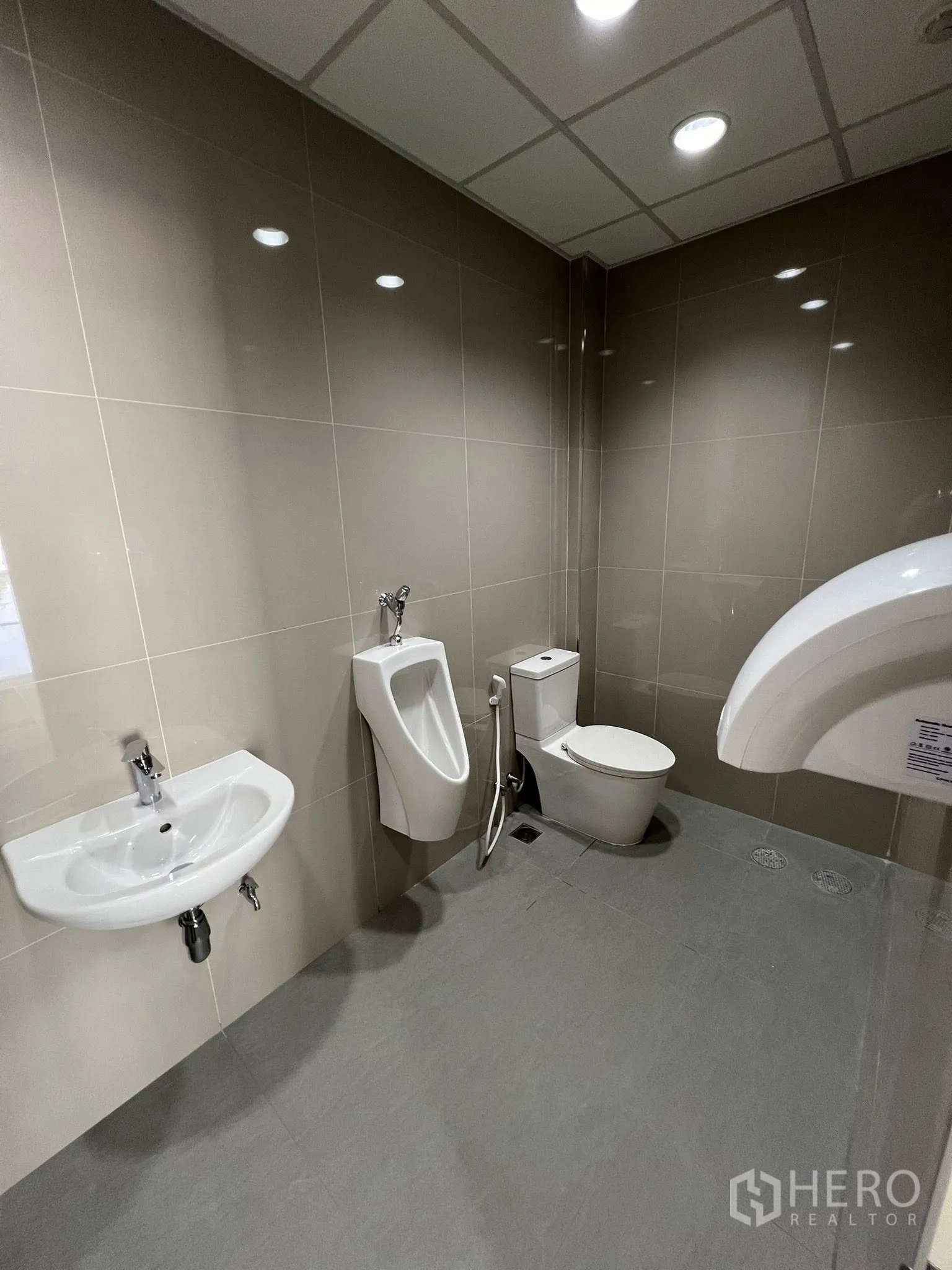 Warehouse for rent in Phra Pradaeng, Samut Prakan - Restroom with urinal, toilet, sink and floor drain for easy maintenance.