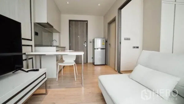 คอนโด ขายในKhlong Toei, Bangkok - มุมมองจากประตูเข้าห้อง เห็นครัว ชุดโต๊ะทานข้าว โซฟา ตู้เย็น และประตูไม้