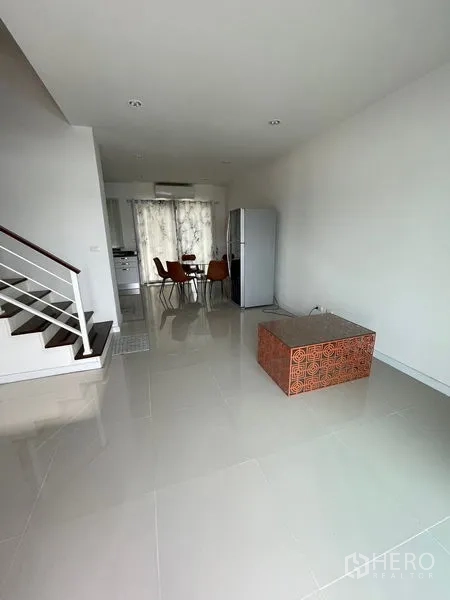 Townhouse for rent in Bang Kapi, Bangkok - Open-plan ground floor with staircase, dining area, kitchenette and refrigerator.