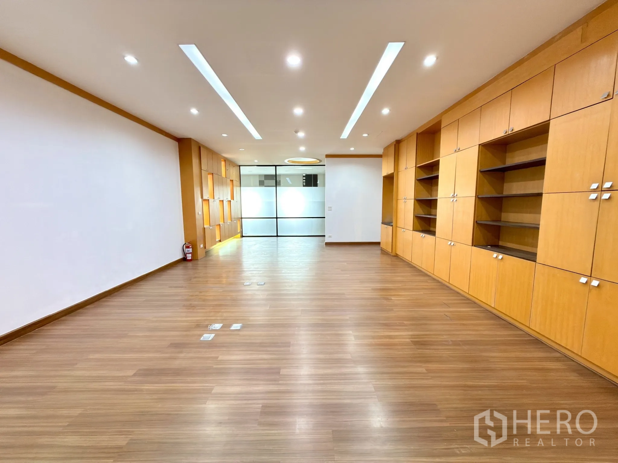 Office Space for rent in Watthana, Bangkok - Central zone with built-in storage and frosted glass doors at the far end.