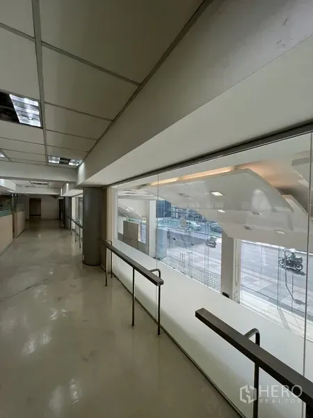 零售空间 出租在Huai Khwang, Bangkok - 夹层走廊，玻璃栏杆俯瞰展厅与街景。