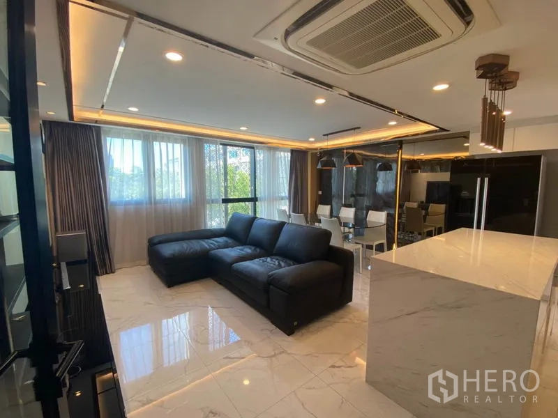 ทาวน์เฮาส์ ขายในYan Nawa, Bangkok - ห้องนั่งเล่นโมเดิร์น โซฟาสีดำ พื้นหินอ่อน เชื่อมต่อมุมทานอาหารและครัวไอส์แลนด์ท็อปหิน