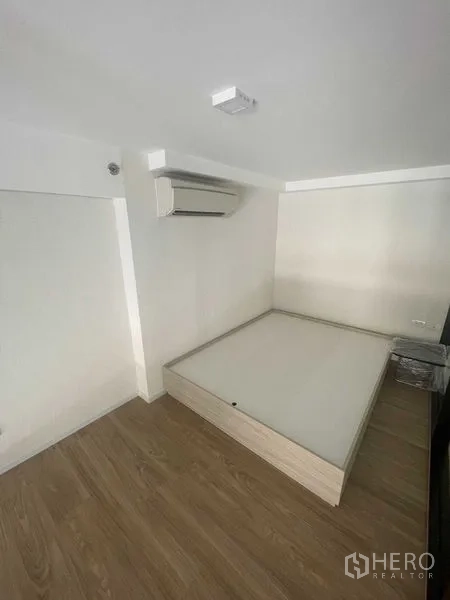 คอนโด ให้เช่าในKhlong Toei, Bangkok - มุมห้องนอนอบอุ่น เตียงยกพื้นและเครื่องปรับอากาศ พื้นไม้