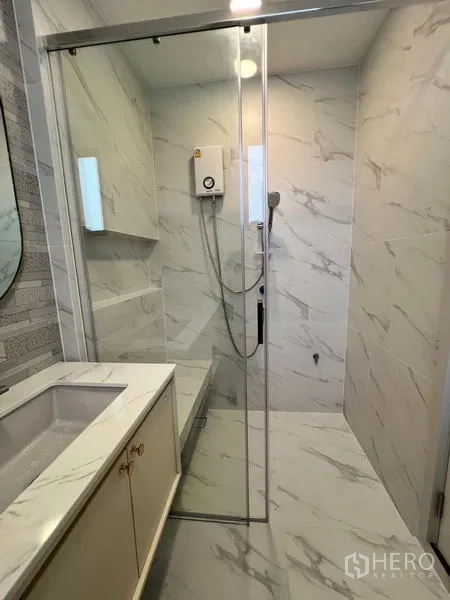 บ้าน ให้เช่าหรือขายในSaphan Sung, Bangkok - ห้องอาบน้ำกรุกระเบื้องลายหินอ่อน พร้อมฉากกั้นกระจกและเคาน์เตอร์อ่างล้างหน้า