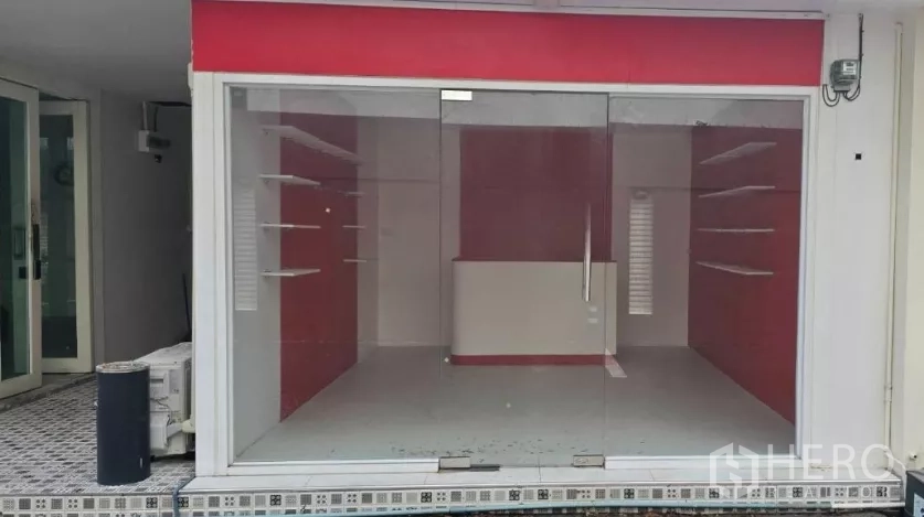 พื้นที่ขายของ for rent in Watthana, Bangkok - หน้าร้านหันถนน กระจกเต็มบาน ป้ายสันสีแดง มองเห็นชั้นโชว์ภายใน