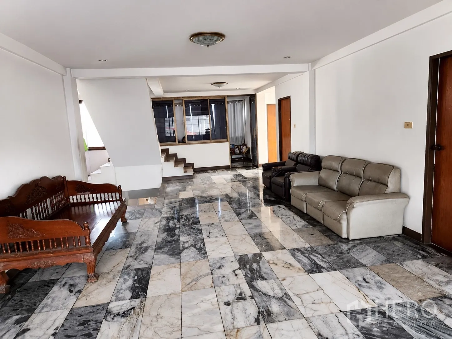 อาคาร standalone for rent or sale in Mueang Pathum Thani, Pathum Thani - พื้นที่ภายในกว้าง พื้นกระเบื้องลายหินอ่อน มีโซฟา ผนังสีขาว และบันได