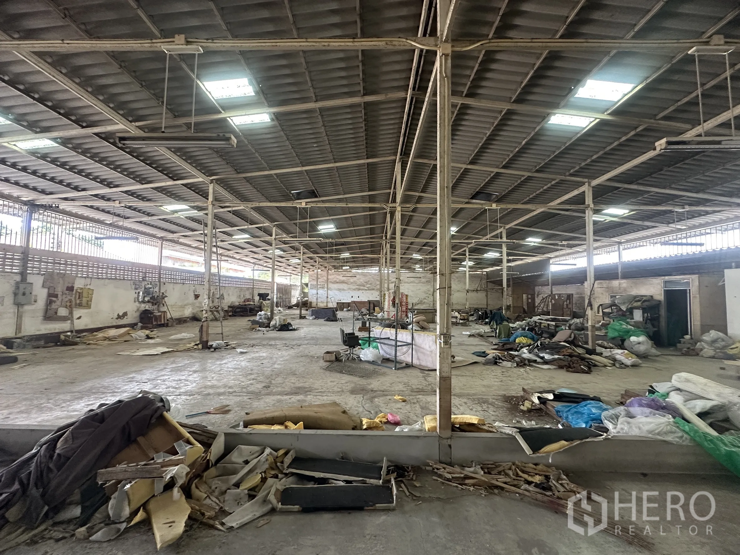 Warehouse for rent in Lam Luk Ka, Pathum Thani - Large warehouse interior with steel columns, metal roof and concrete floor.