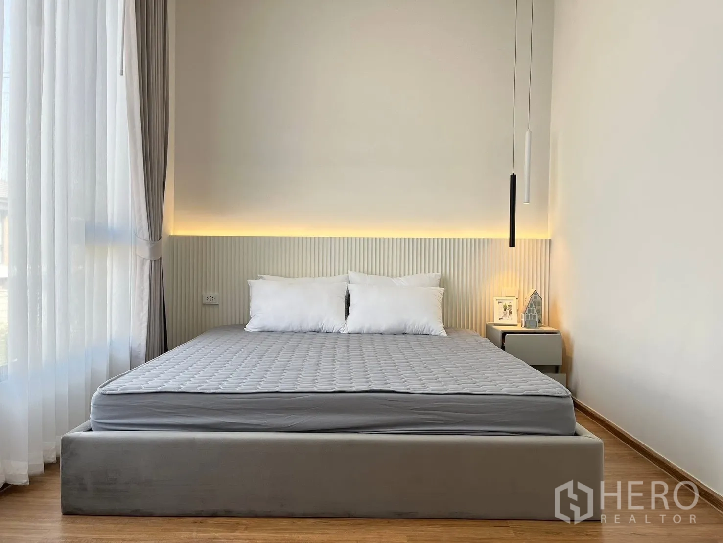 联排别墅 出租在Bang Phli, Samut Prakan - 主卧，软包床，床头氛围灯，床头柜与纱帘。