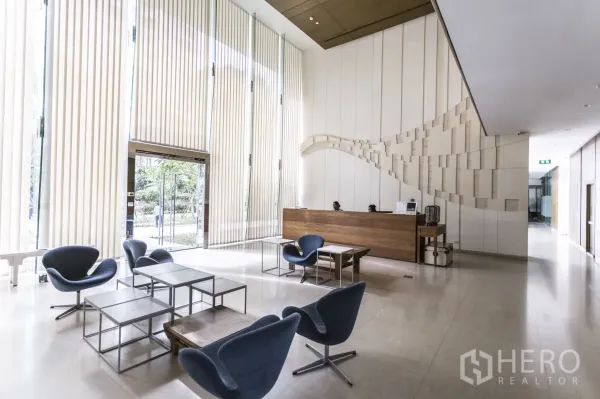 Condominium for rent in Bang Lamung, Chon Buri - Modern condominium lobby with high ceilings, reception desk, and lounge seating.