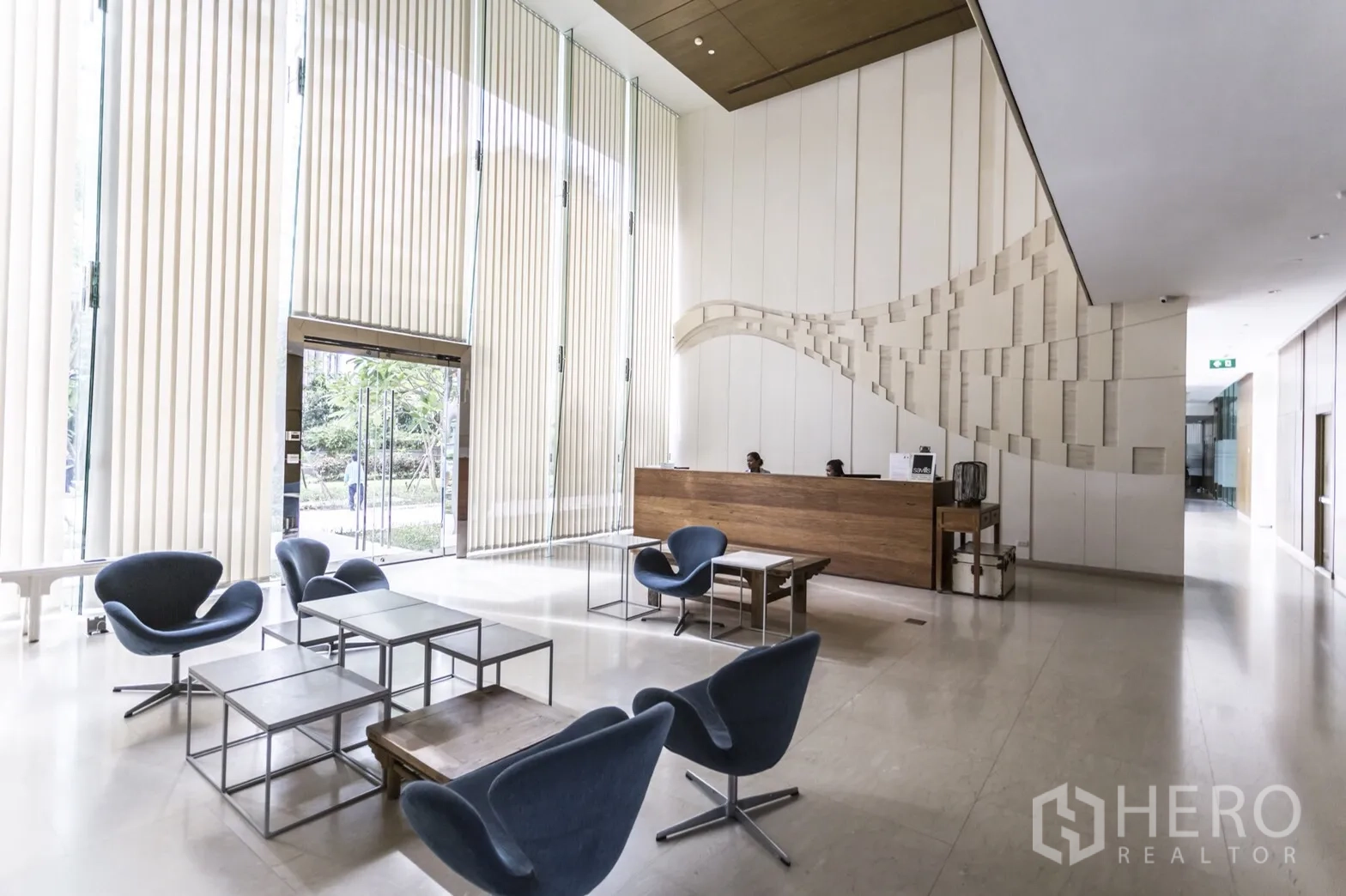 Condominium for rent in Bang Lamung, Chon Buri - Modern condominium lobby with high ceilings, reception desk, and lounge seating.