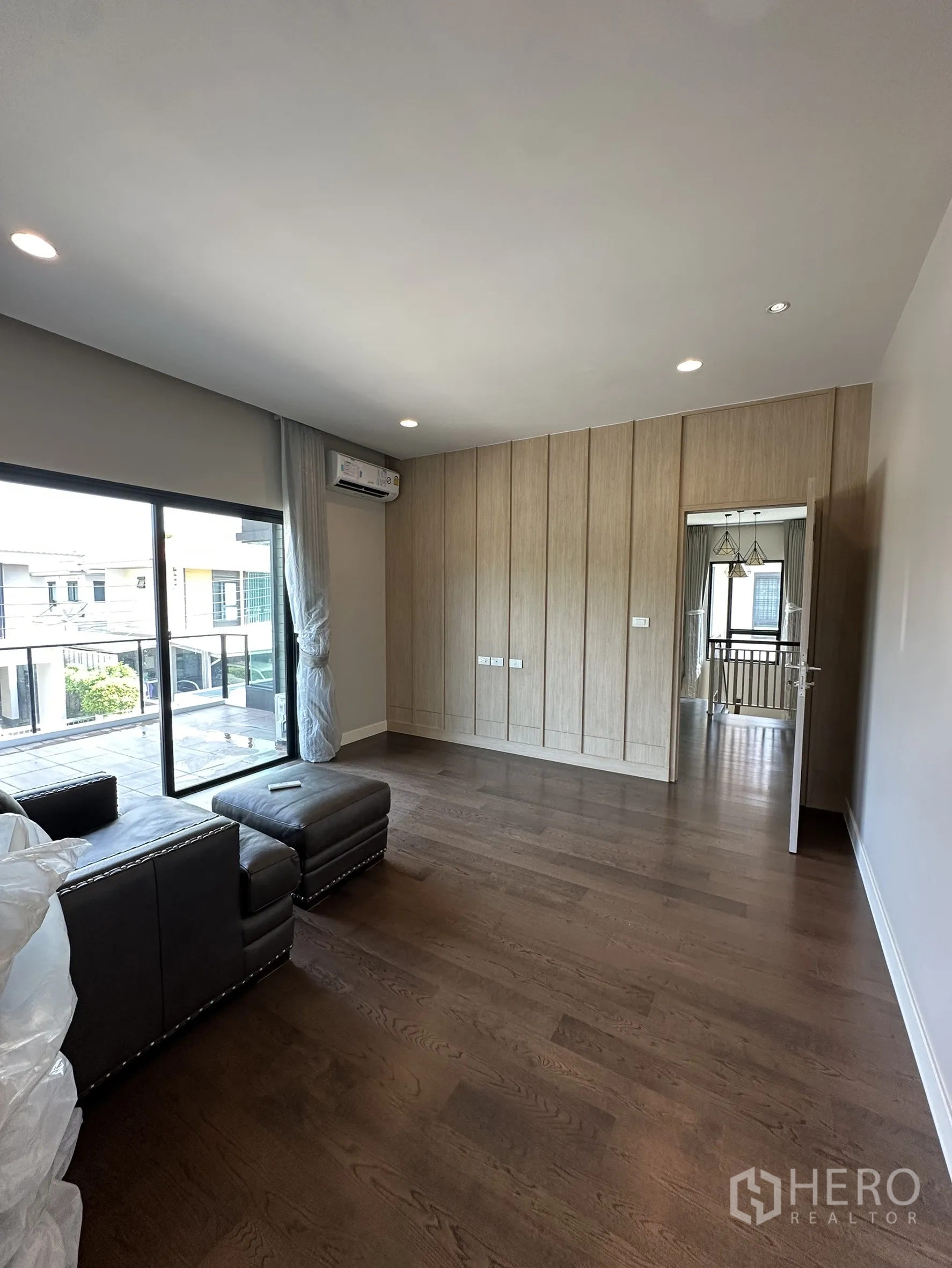 บ้าน ขายในLam Luk Ka, Pathum Thani - ห้องอเนกประสงค์ชั้นบนหรือห้องนอน พื้นไม้เข้ม และทางออกสู่ระเบียง