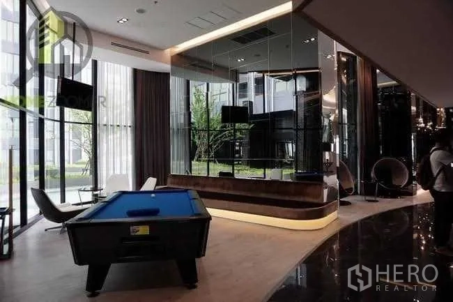 Condominium for sale in Bang Rak, Bangkok - Residents’ lounge featuring a pool table, floor‑to‑ceiling windows and sleek modern décor.