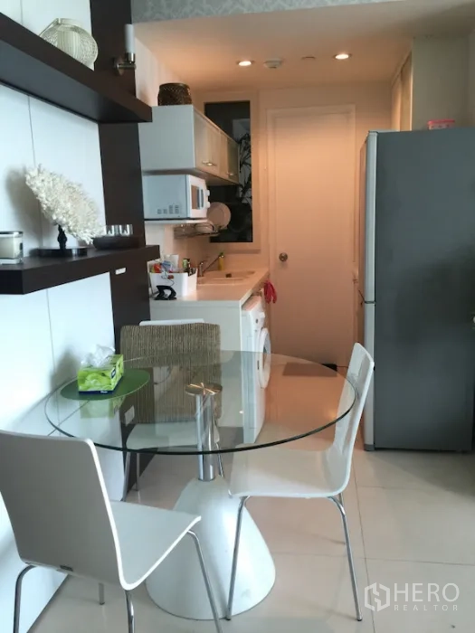 公寓 出租或出售在Ratchathewi, Bangkok - 一线式厨房与玻璃餐桌，配橱柜、微波炉和洗衣机。