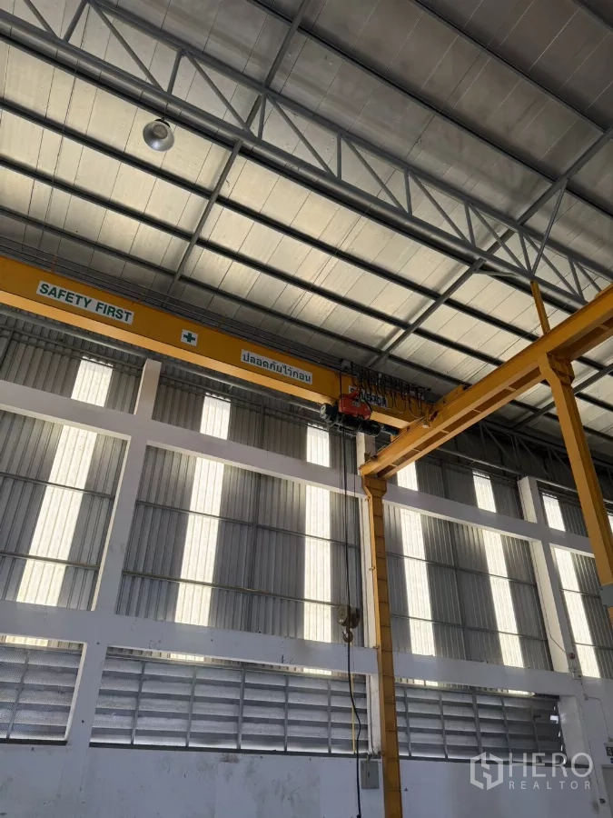 工厂 出租或出售在Bang Phli, Samut Prakan - 黄色桥式行车与钢结构屋架特写。
