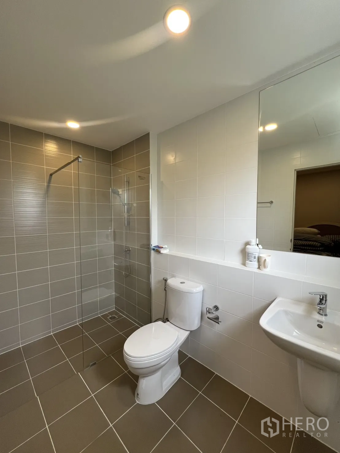 Detached House for rent in Lat Krabang, Bangkok - Contemporary bathroom with glass shower screen, toilet, and wall-mounted sink.