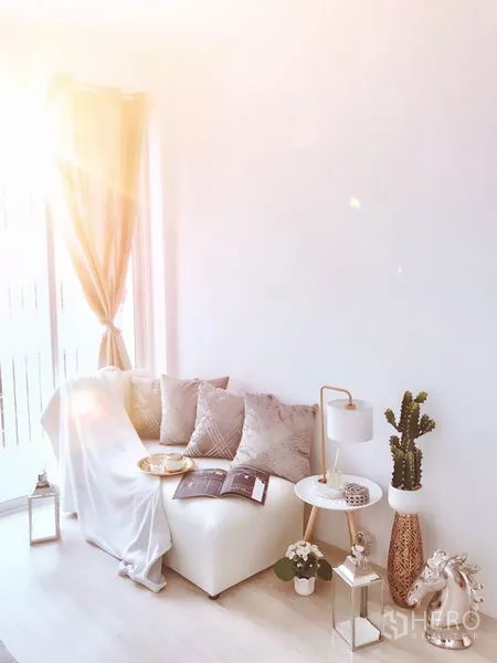 Retail Space for rent in Khlong Toei, Bangkok - Cozy lounge area with a white sofa, curtains and side tables lit by afternoon sun.