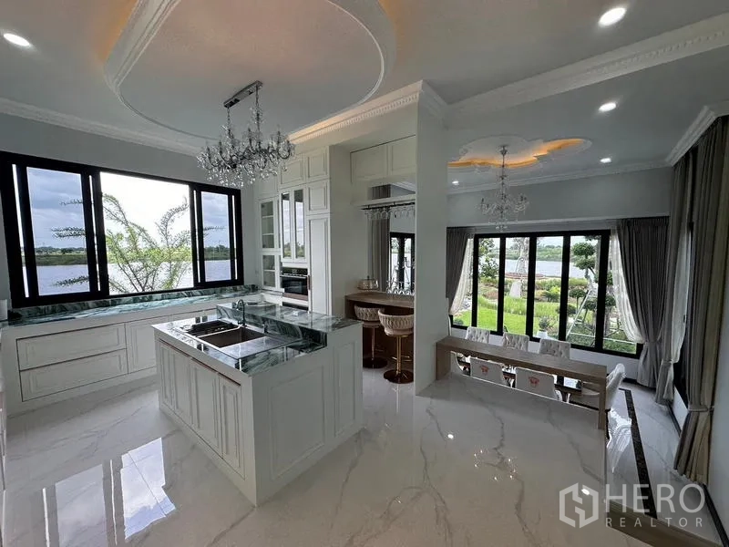 Detached House for sale in Sai Noi, Nonthaburi - Kitchen and breakfast bar flowing to dining area with panoramic greenery views.