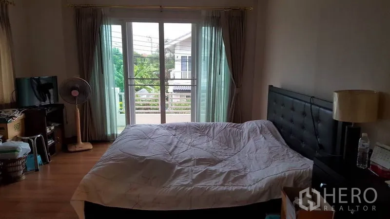 บ้าน ขายในMueang Nonthaburi, Nonthaburi - ห้องนอนหลัก พื้นไม้ ประตูกระจกเปิดสู่ระเบียง มองเห็นสวน