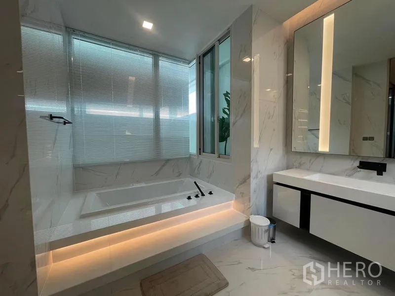 Detached House for rent in Bueng Kum, Bangkok - Spa-style bathroom featuring a built-in soaking tub with LED lighting and large mirrors.